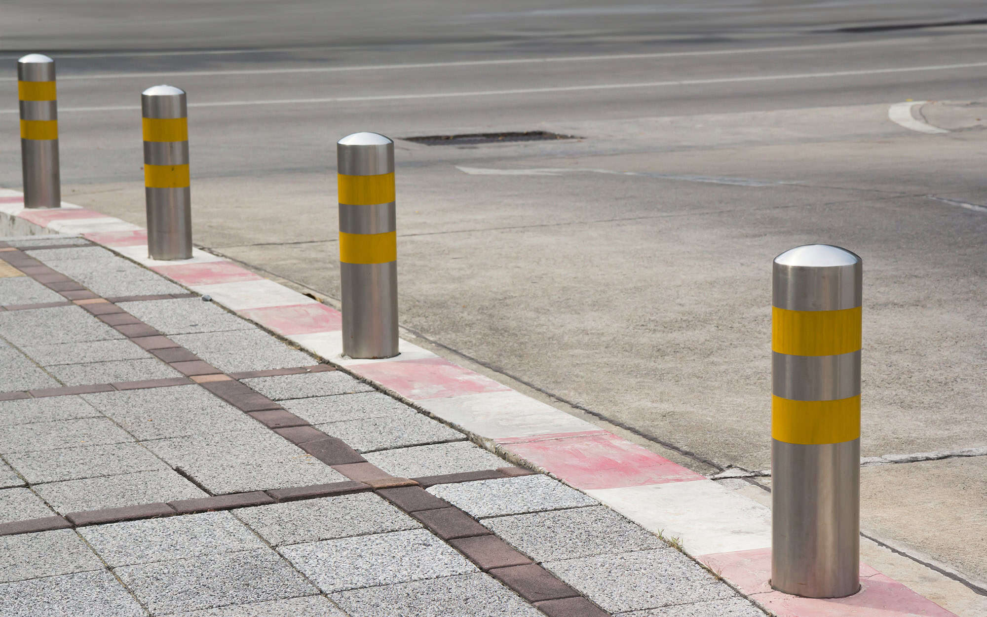 Stainless Steel bollards on grey stone pavement