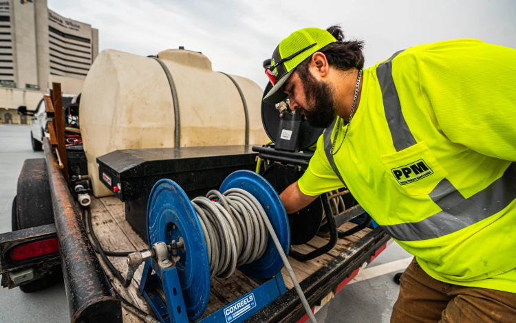 PPM technician setting up equipment for pressure washing